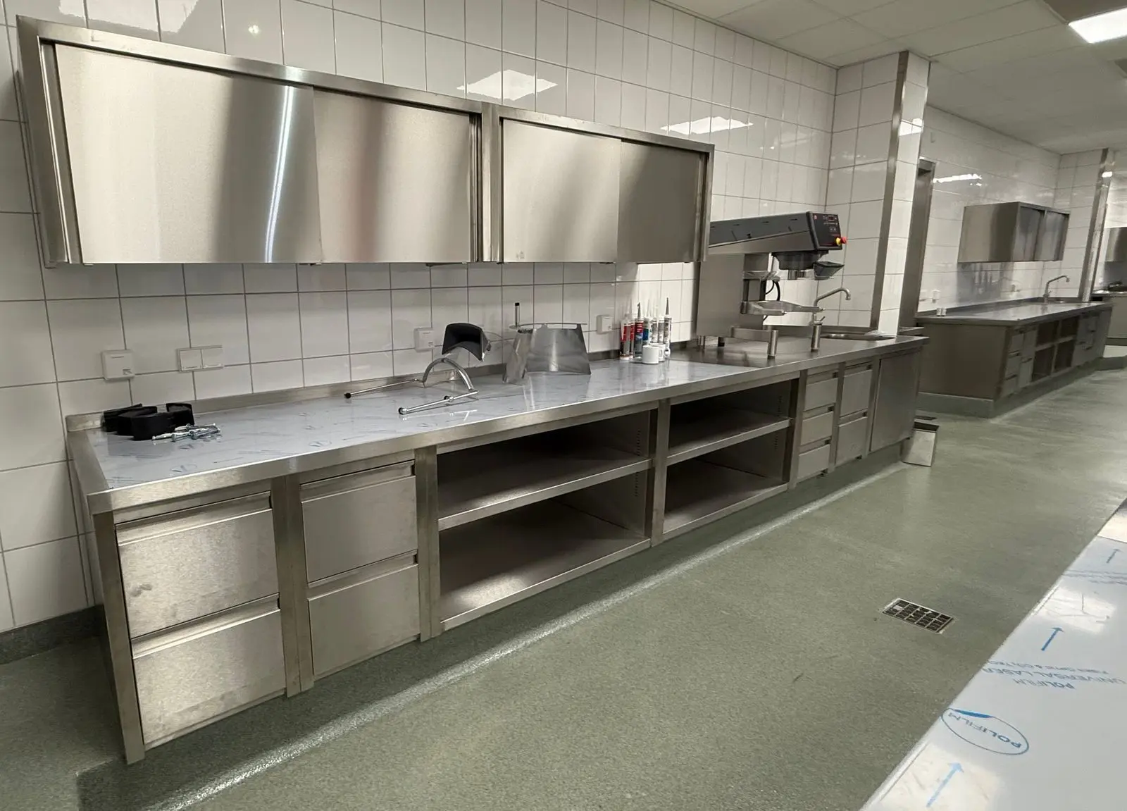 Großküche mit Edelstahl-Arbeitstischen und Wandhängeschränken