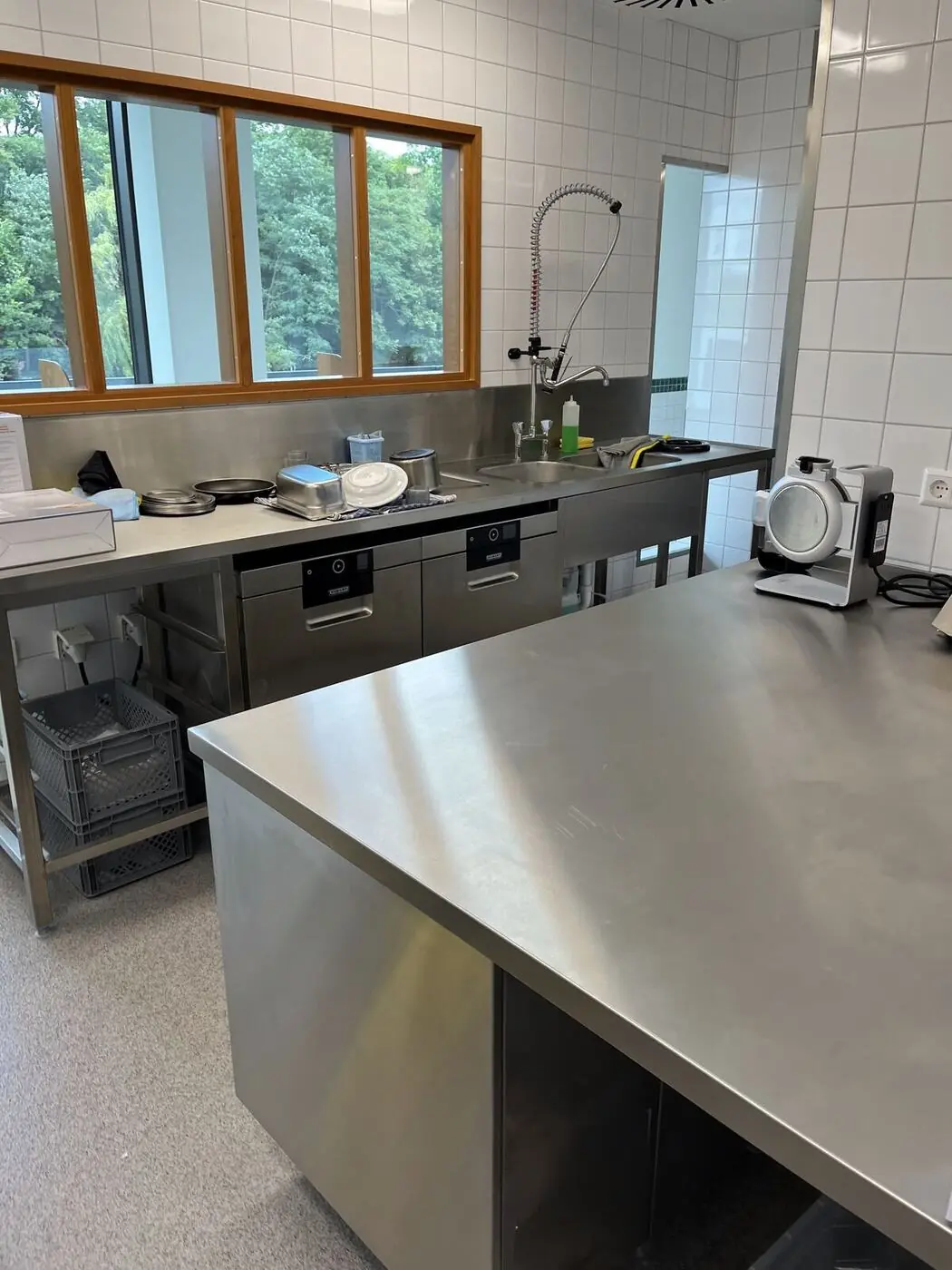 Edelstahl-Arbeitstisch mit Schränken in einer Gastronomieküche